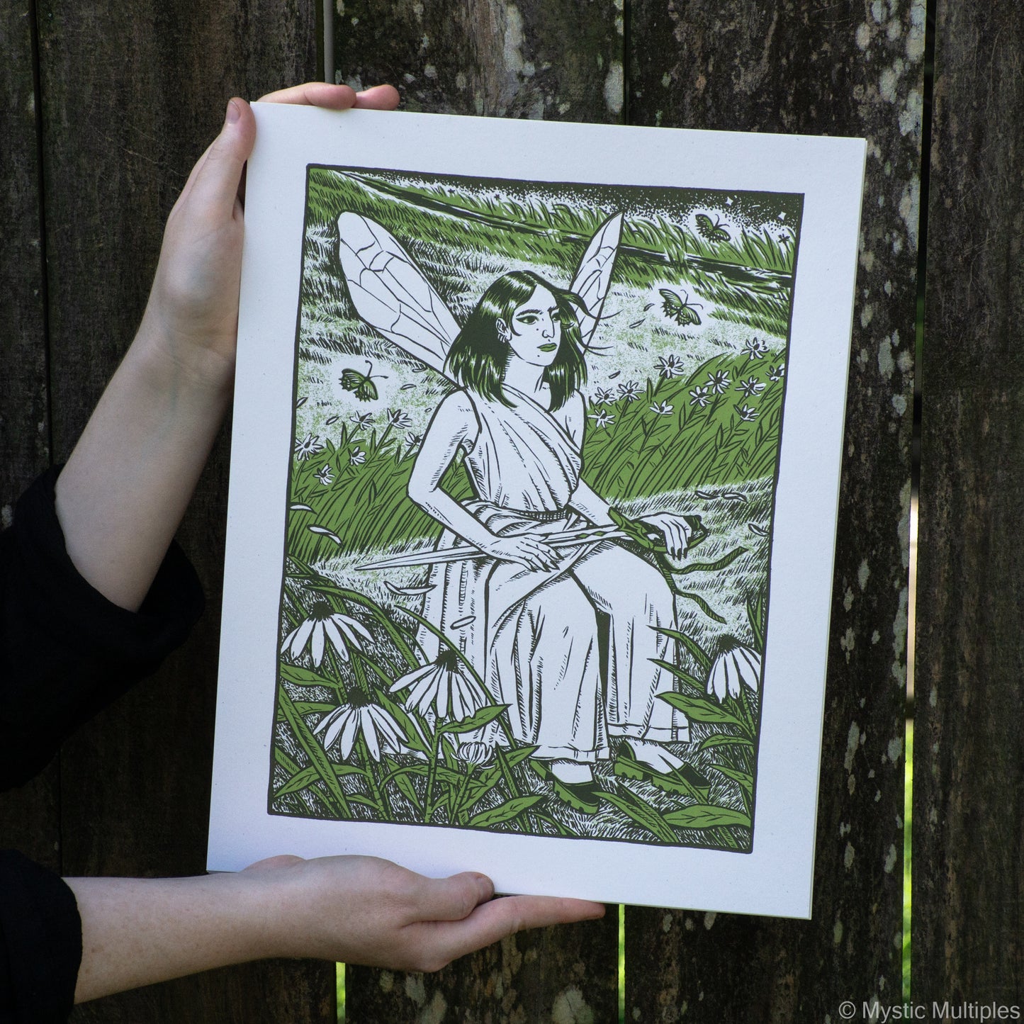 The queen of swords, sword in lap, sitting in a prairie surrounded by glowing butterflies