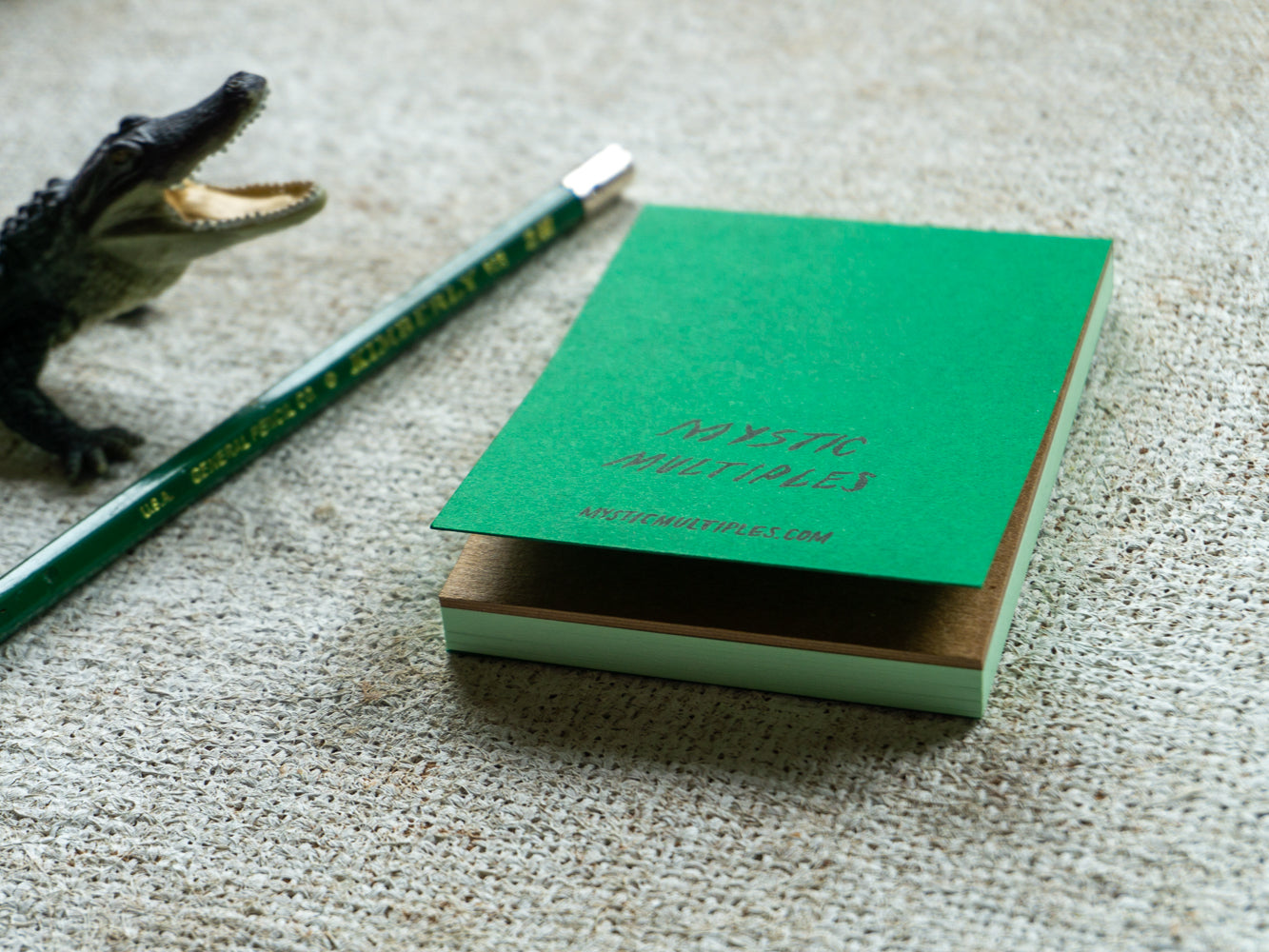 Mystic Multiples green notepad with toy alligator.